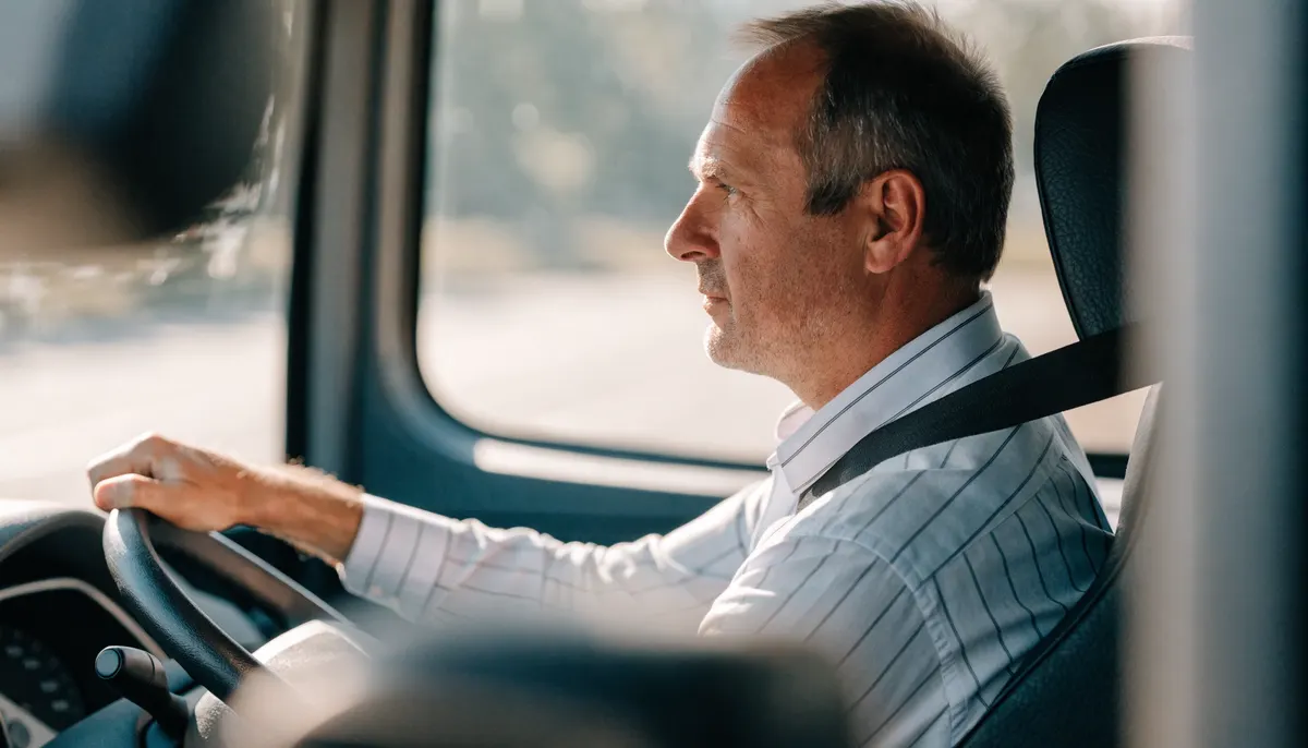 Conductor de autobús al volante recibiendo pasajeros